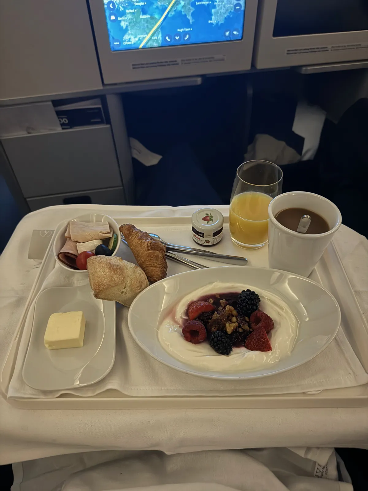 Business Class Frühstück: Joghurt mit Beeren, Croissant und Kaffee