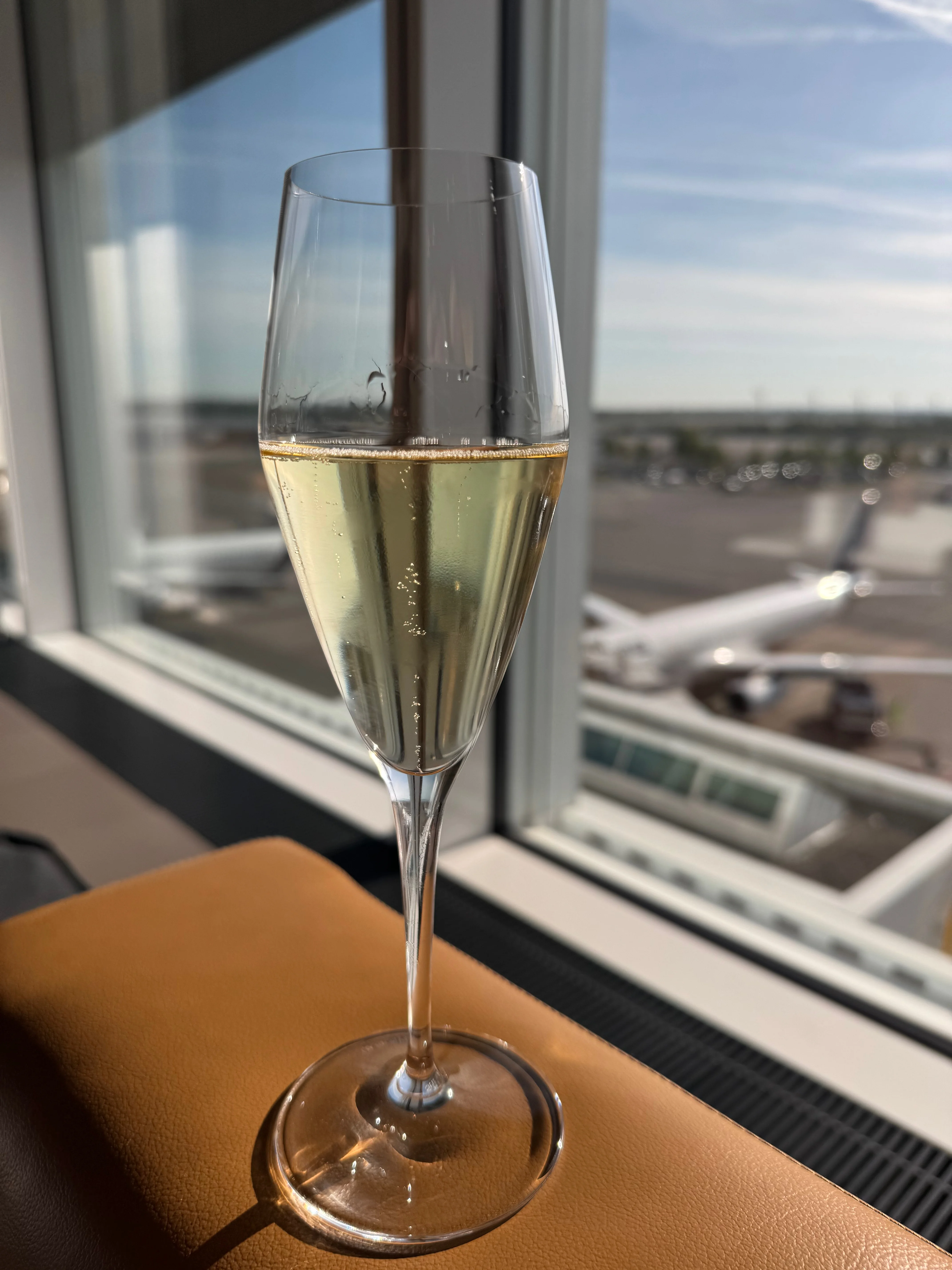 Champagnerglas mit Blick auf das Vorfeld am Münchner Flughafen
