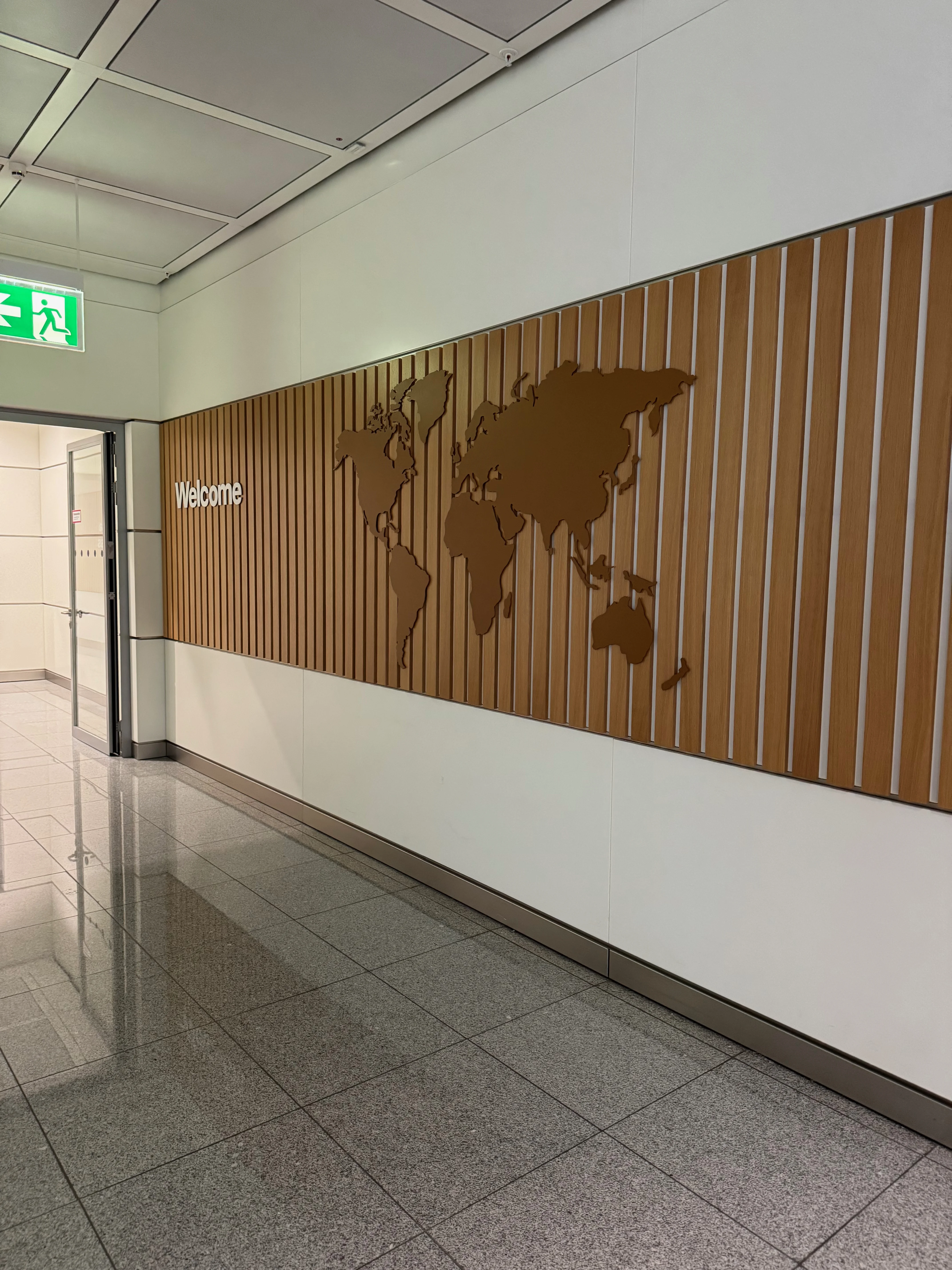 Welcome-Wand mit Weltkarte im Eingangsbereich der First Class Lounge